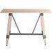 A Lancaster Table & Seating bar height trestle table with wooden live edge top and metal legs.