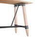 A Lancaster Table & Seating bar height wooden table with a live edge and metal trestle legs.