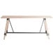 A Lancaster Table & Seating bar height trestle table with a wooden top and metal legs.
