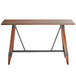 A Lancaster Table & Seating bar height wooden table with live edge and metal legs.