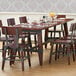 A Lancaster Table & Seating solid wood dining table with antique mahogany finish and trestle legs.