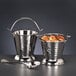 Two silver Libbey Sonoran stainless steel pails with spoons on a table.