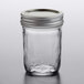 A Ball glass canning jar with a silver metal lid on a table.