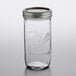 A Ball wide mouth glass canning jar with a silver metal lid.