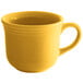 A close-up of a Tuxton saffron yellow coffee cup with a handle on a white background.