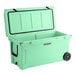 A seafoam green CaterGator outdoor cooler with wheels.