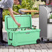 A man opening a CaterGator seafoam cooler to put a beer in.