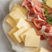 A plate with cheese and meat including Danish Creamy Havarti cheese.