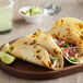 Mission Super Soft Yellow Corn Tortillas filled with meat and vegetables on a wooden plate.