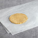 A close up of a round yellow Mission Super Soft corn tortilla on white paper.
