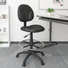 A Boss black fabric drafting stool with a metal base.