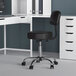 A Boss black adjustable office stool with a black seat.