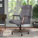 A Boss slate gray linen office chair with wooden armrests and base.
