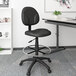 A black Boss drafting stool with a metal base.