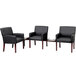 A group of Boss black leather chairs with wooden legs around a table.