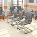 A group of Boss gray vinyl ribbed side chairs with chrome frames in a room.