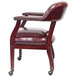 A Boss burgundy vinyl captain's chair with wheels and studded arms.