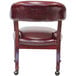 A Boss burgundy vinyl Captain's chair with wheels and a cushioned backrest.