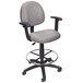 A Boss gray drafting stool with black wheels and base.