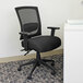 A Boss black mesh office chair with arms and wheels.