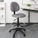 A gray Boss drafting stool with a metal base and black footring.