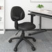 A black Boss office chair with wheels and adjustable arms.