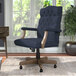 A navy blue Boss office chair with a wooden base and armrests.