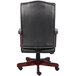 A black leather Boss office chair with mahogany finish.