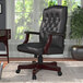 A Boss black leather office chair with a wooden base.