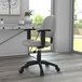 A gray Boss Perfect Posture office chair with wheels and adjustable arms on a black base.