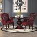 A table with a Boss burgundy wingback chair next to it.