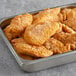 A tray of Brakebush Gold'N'Spice breaded chicken tenderloins on a table.