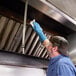 A man wearing gloves cleaning a stainless steel grill with Scotch-Brite stainless steel wipes.