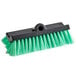 A close-up of a green Carlisle vehicle and wall cleaning brush with black bristles.
