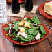 A Fiesta® Scarlet square luncheon plate with salad, meat, and croutons on it.
