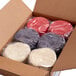 A box with plastic-wrapped stacks of red, grey, and white round tortillas.