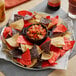 A plate of Mission tri-color tortilla chips with salsa on a table.