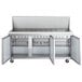 An Avantco stainless steel refrigerated sandwich prep table with three doors on a counter.