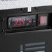 A close-up of a temperature control panel on a black Avantco APT-71M-HC refrigerated sandwich prep table.