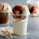 A Fabri-Kal Greenware compostable plastic parfait cup with fruit and yogurt in it.