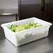 A white Rubbermaid food storage container on a counter filled with chopped lettuce.