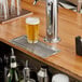 A Regency stainless steel flush mount beer drip tray on a bar counter.