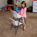 A girl holding an almond Lifetime Children's Stacking Chair.
