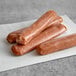 Warrington Farm Meats Jerk Chicken sausages in plastic wrap on a white surface.