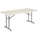 A white rectangular Lifetime plastic fold-in-half table with metal legs.