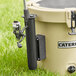 A CaterGator fishing rod holder on a round container on grass.