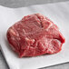 A Warrington Farm Meats frozen filet mignon steak on white paper
