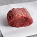 A Warrington Farm Meats frozen filet mignon steak on white paper.