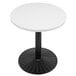 A white circular Art Marble Furniture quartz table top on a table with a black base.