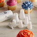 A white plastic container holding Ateco Cupcake Decorating Set with cupcakes decorated using blue and pink frosting.